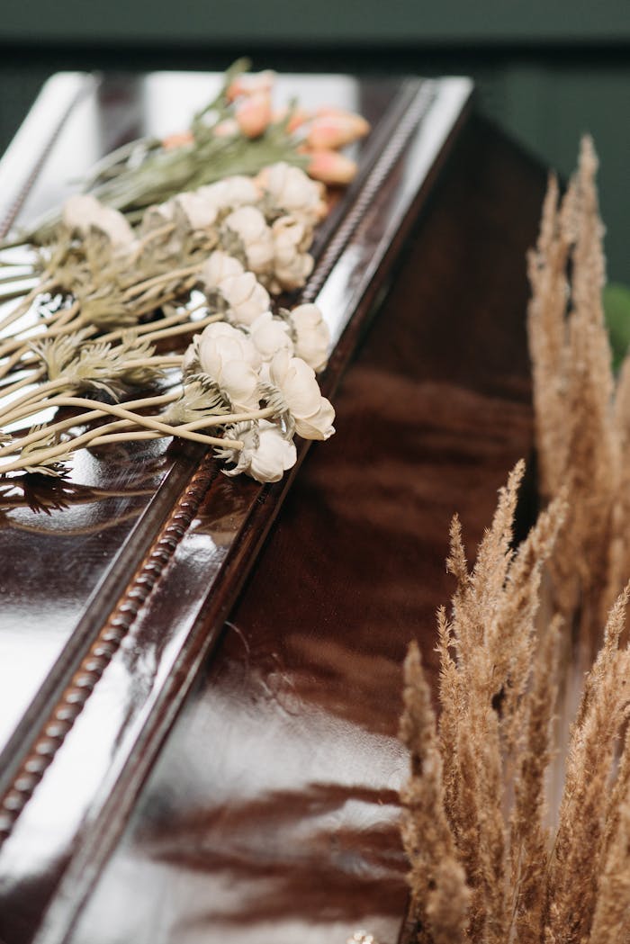 home-hero Close-up of a polished coffin adorned with delicate flowers, symbolizing loss and remembrance.
